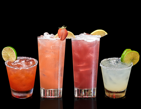 Four colorful cocktails in various glasses garnished with lime, strawberry, and lemon slices, displayed against a black background.
