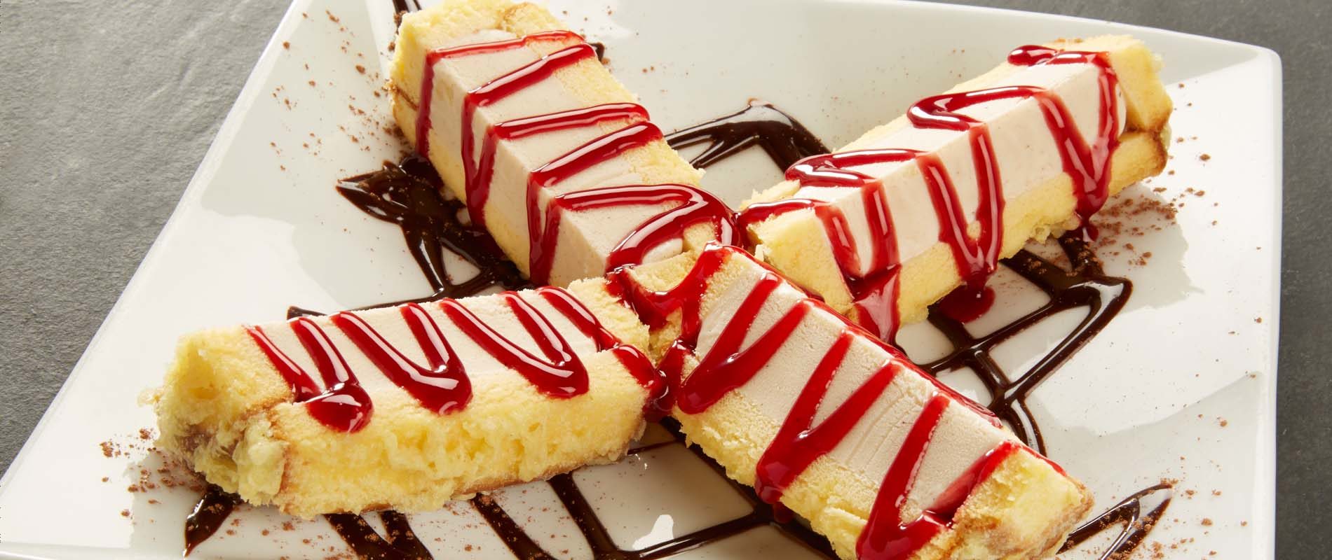 Battered cinnamon-swirl ice cream, finished with raspberry and chocolate sauces, arranged in a X shape on a square white plate.